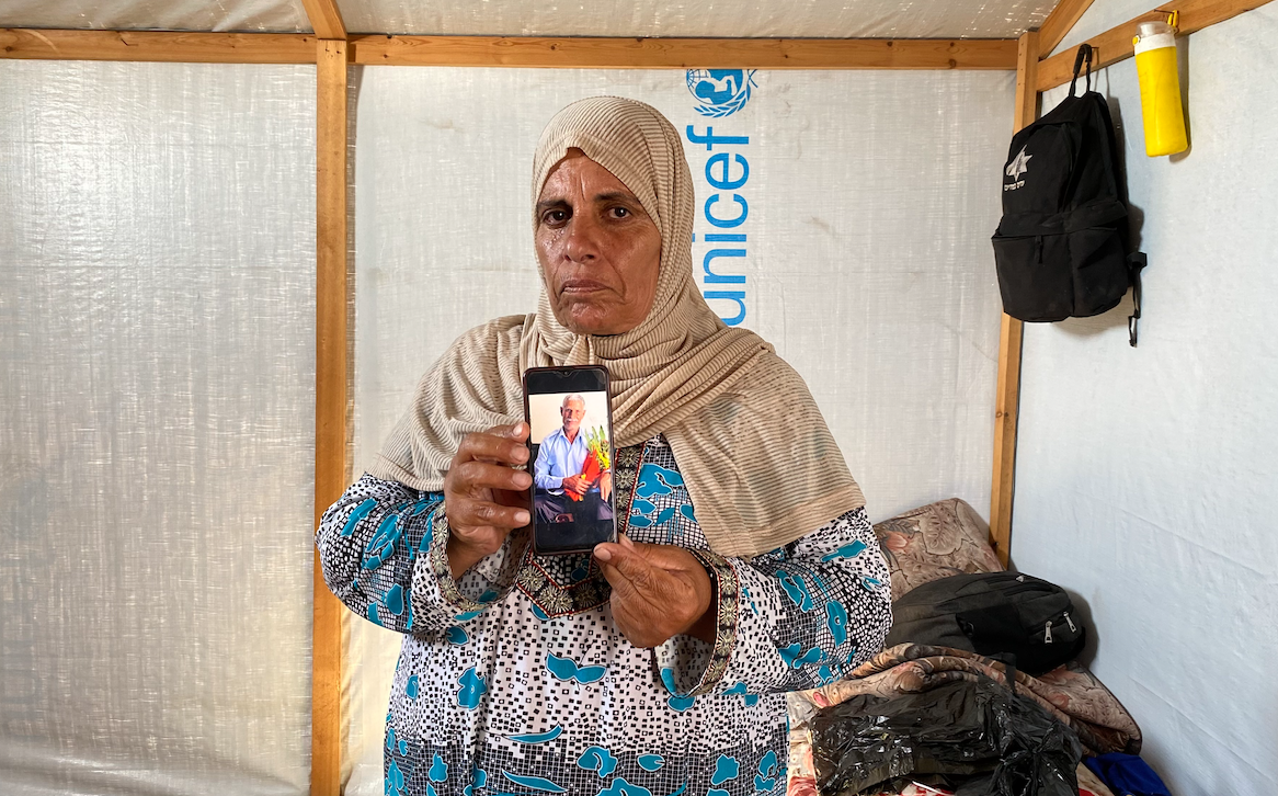 سلوى أبو مصطفى داخل خيمتها تعرض صورة لزوجها الشهيد أحمد أبو مصطفى