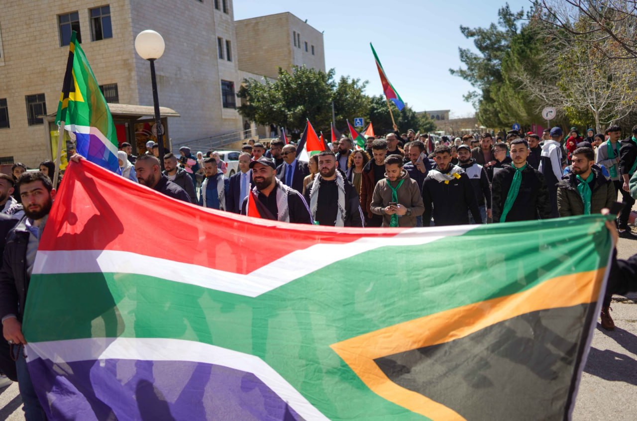 طلبة في جامعة بيرزيت يحملون علم جنوب افريقيا