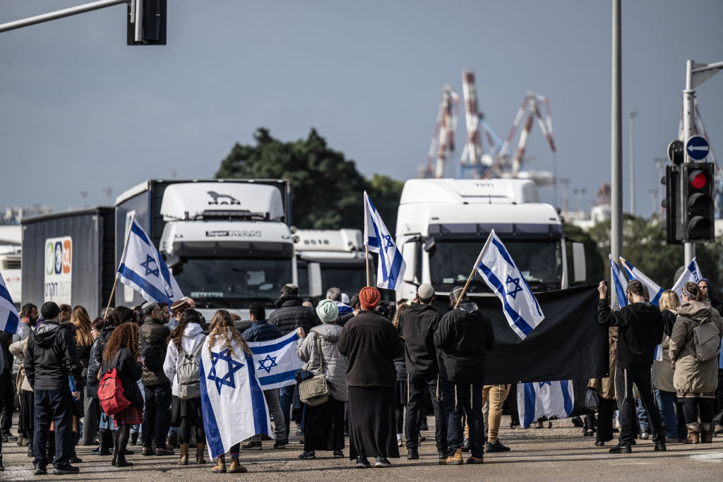 متظاهرون يجلسون أمام الشاحنات في أسدود لمنع توجهها لغزة