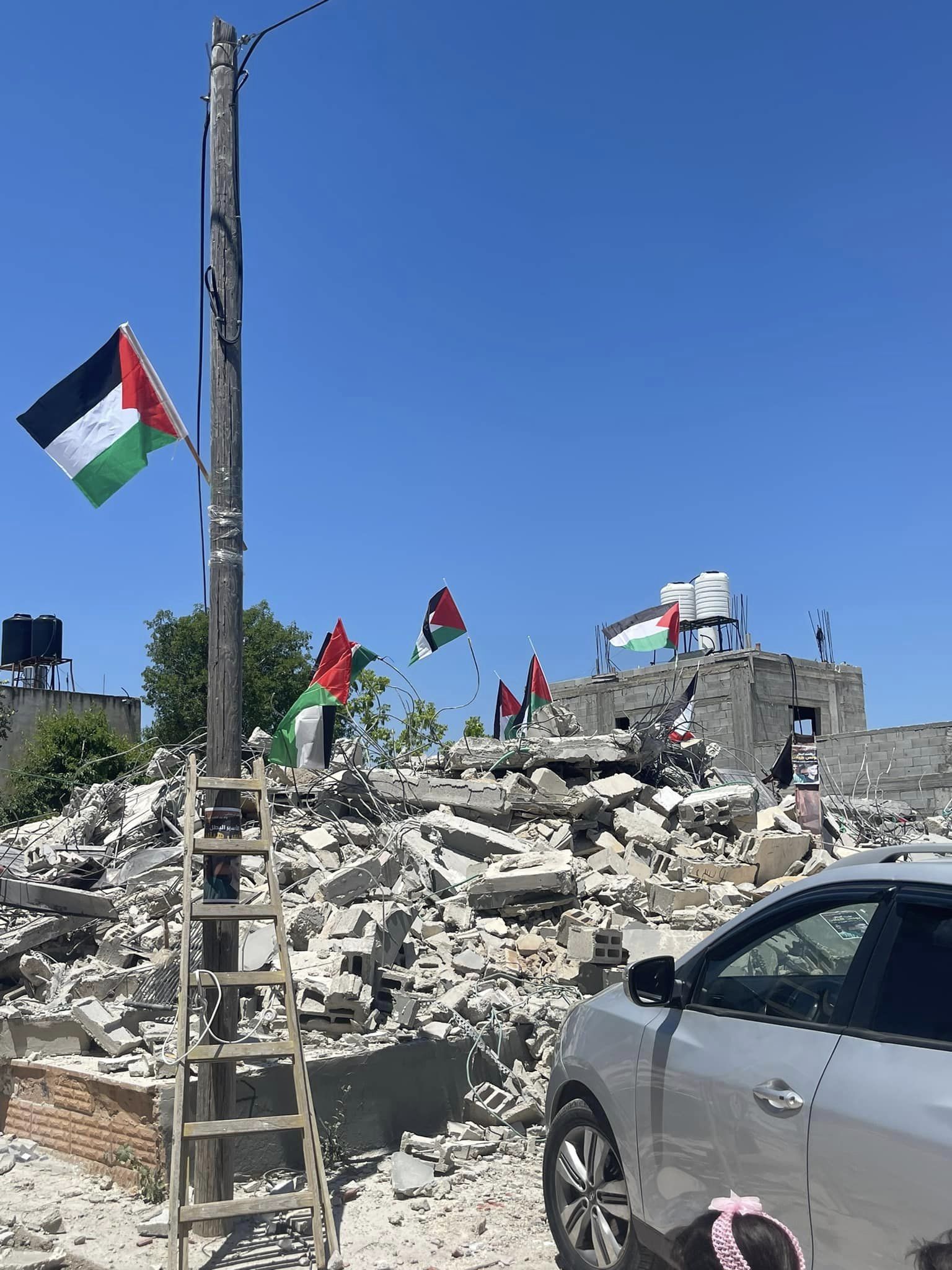 منزل عائلة هيلان، المهدوم، ترفرف على أنقاضه أعلام فلسطين (مصدر الصور: العائلة)