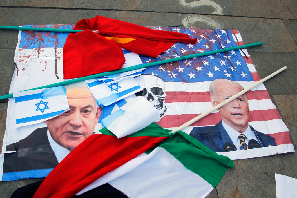 : طبعت أعلام الولايات المتحدة وإسرائيل بالطلاء الأحمر على الأرض مع وجوه الرئيس جو بايدن ورئيس الوزراء بنيامين نتنياهو خلال مظاهرة لدعم فلسطين في 29 نوفمبر 2023 في ميديلين، كولومبيا.