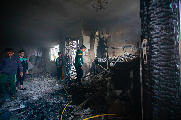 فلسطينيون يتفقدون منزلاً مدمرًا  بسبب قصف إسرائيلي في مخيم جنين