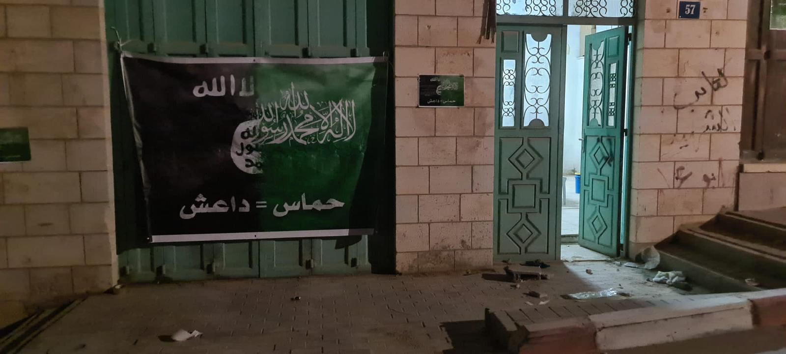 يافطة تركها جنود الاحتلال أمام مقرّ الجمعية الخيرية الإسلامية لرعاية الأيتام في يطا