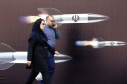 إيرانيان يسيران بجانب جدارية تمثل الضربة الإيرانية لإسرائيل، في العاصمة طهران ((EPA.