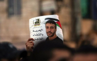 رفع صورة مطالبة بالإفراج عن الأسير ناصر أبو حميد، خلال مسيرة تضامن معه 