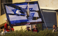 متظاهرون يحملون لافتة تشير إلى أن نتنياهو يتسبب بتمزيق (دولة إسرائيل) في مظاهرة في تل أبيب