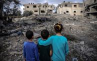 أطفال يقفون قبالة منازلهم المدمّرة جرّاء القصف الإسرائيلي الذي استهدف دير البلح - MOHAMMED ABED/ Getty 