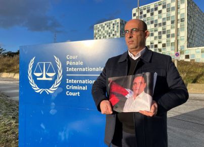 غسان بنات شقيق نزار يحمل صورته أمام مقر المحكمة الجنائية الدولية في لاهاي - DANNY KEMP/ Getty