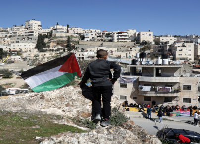 طفل يرفع علم فلسطين قبالة البناية المهددة بالهدم في حي واد قدوم في سلوان | تصوير سعيد القاق