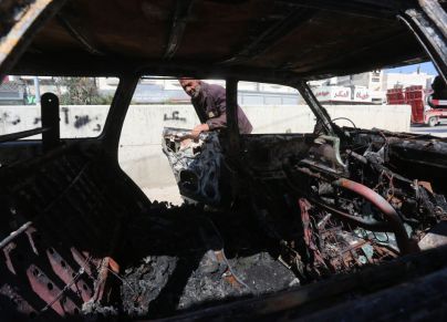 فلسطيني يتفقد سياراته في حوارة بعد حرقها على يد المستوطنيين. تصوير نضال اشتية