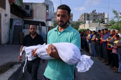 أب يحمل طفلته التي قضت في غارات إسرائيلية على غزة - SAID KHATIB/ Getty Images