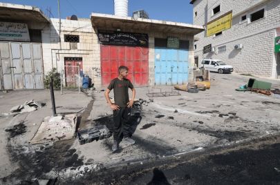  GETTY Images مواطن يتفقد الأضرار في قرية حوارة بالضفة الغربية في 6 أكتوبر 2023، بعد هجوم شنه مستوطنون إسرائيليون خلال الليل.