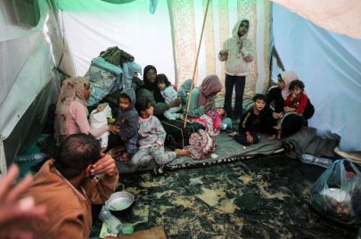 غزيّون في مخيمهم خلال يوم ممطر في مستشفى شهداء الأقصى في دير البلح وسط قطاع غزة في 14 نوفمبر 2023