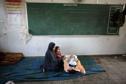  نوفمبر 2023 18 .امرأة نازحة مع أطفالها في مدرسة تابعة للأونروا في دير البلح