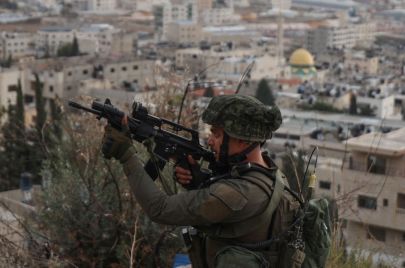جندي إسرائيلي يصوب بندقيته خلال مداهمة لمخيم بلاطة للاجئين الفلسطينيين شرق نابلس بالضفة الغربية المحتلة في 19 نوفمبر 2023