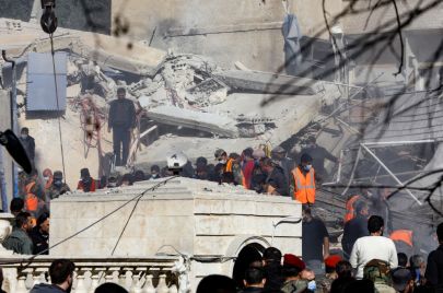 عمال إنقاذ يتجمعون أمام المبنى الذي استهدفته غارة إسرائيلية في دمشق في 20 يناير، 2024