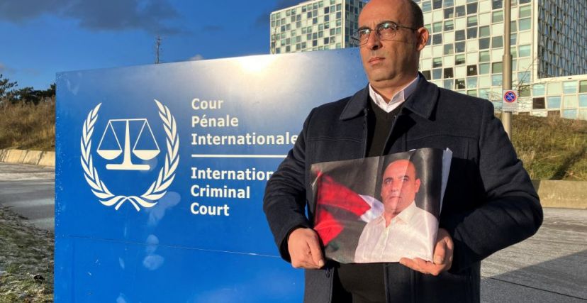 غسان بنات شقيق نزار يحمل صورته أمام مقر المحكمة الجنائية الدولية في لاهاي - DANNY KEMP/ Getty