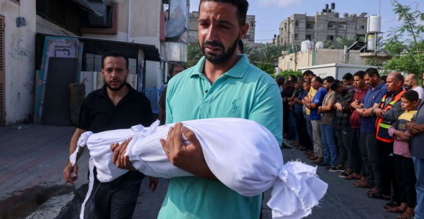أب يحمل طفلته التي قضت في غارات إسرائيلية على غزة - SAID KHATIB/ Getty Images