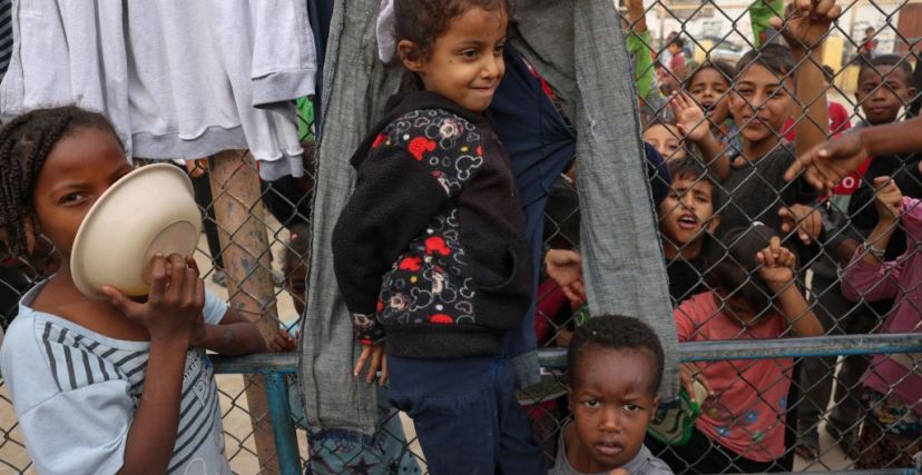 أطفال فلسطينيون نازحون يتجمعون لتناول الإفطار في مخيم للاجئين في رفح بجنوب قطاع غزة، في 12 نوفمبر 2023