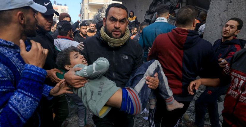 رجل يحمل طفلاً أصيب في قصف إسرائيلي على رفح في جنوب قطاع غزة في 20 نوفمبر 2023، تصوير محمود حمص 