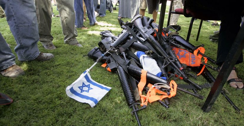 إسرائيليون يقفون بجوار كومة من الأسلحة التي سلمها المستوطنون المقيمون في مستوطنة جاني تال جنوب قطاع غزة في 8 أغسطس 2005