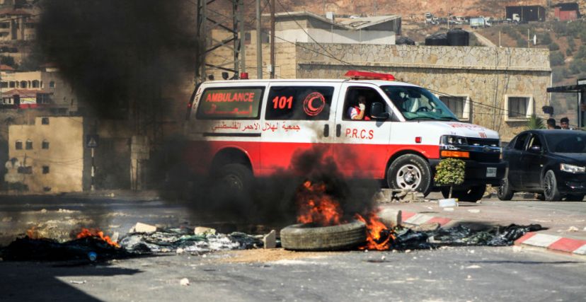 سيارة إسعاف تمر بين الإطارات المشتعلة أثناء اقتحام قوات الاحتلال الإسرائيلي مدينة طوباس شمال الضفة الغربية.