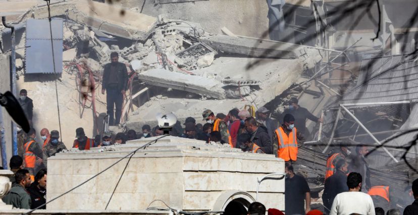 عمال إنقاذ يتجمعون أمام المبنى الذي استهدفته غارة إسرائيلية في دمشق في 20 يناير، 2024