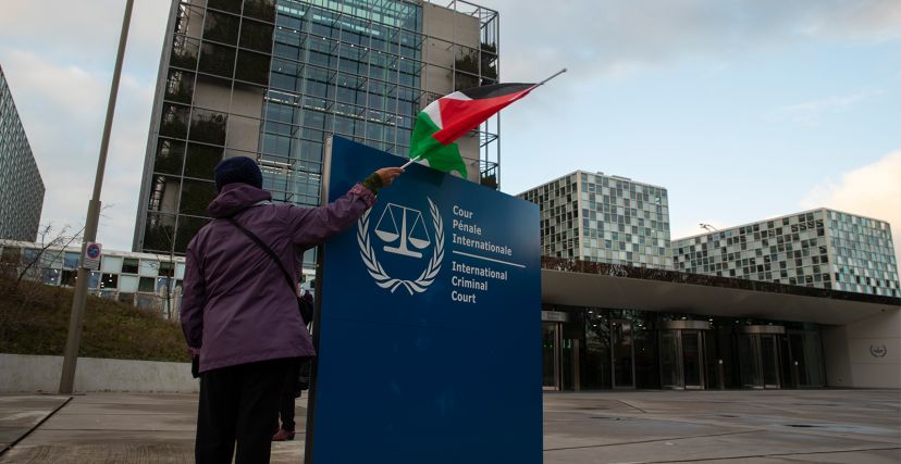 متظاهر يحمل العلم الفلسطيني خارج المحكمة الجنائية الدولية في لاهاي بهولندا – أرشيف
