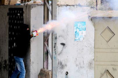 فلسطيني يستخدم المفرقعات في مواجهات مع الجنود الإسرائيليين شمال القدس - (Anna Ferensowicz/ Getty Images)